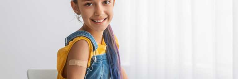 a girl smiling with a bandage on her shoulder